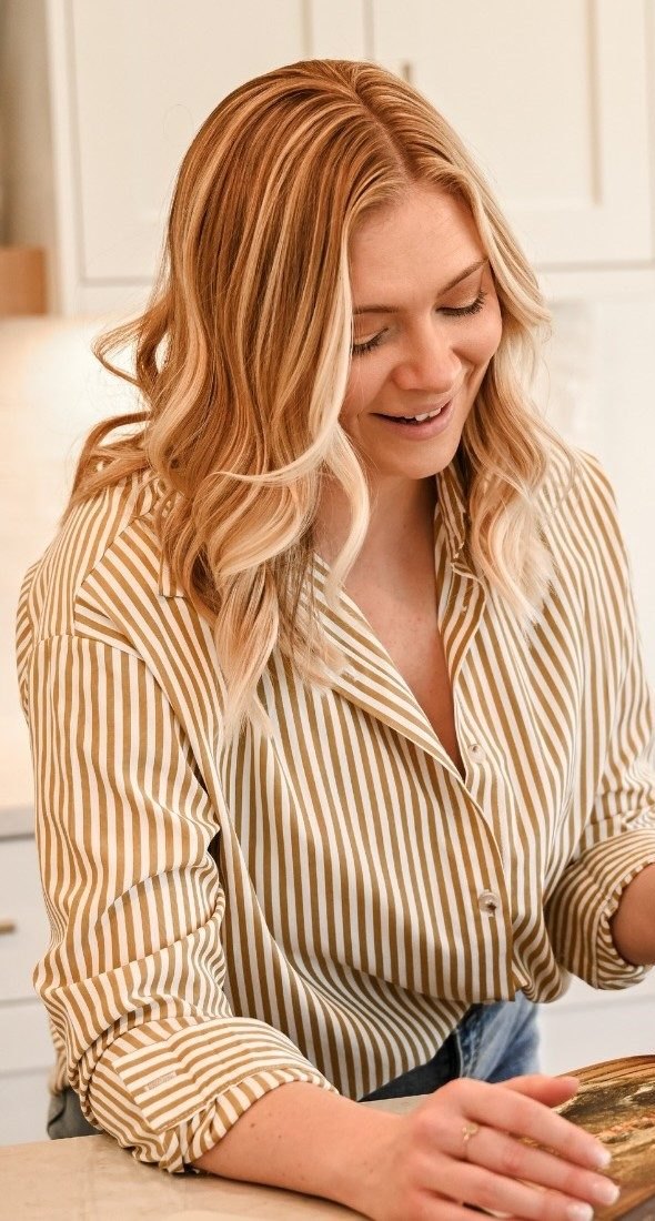 Kyrsten Smith smiling while looking through a design book.